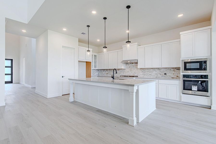 Chef’s kitchen boasting a large island, pendant lighting, and sleek cabinetry