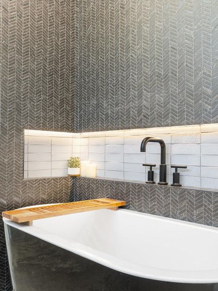 Bathroom view of a tub and tile walls