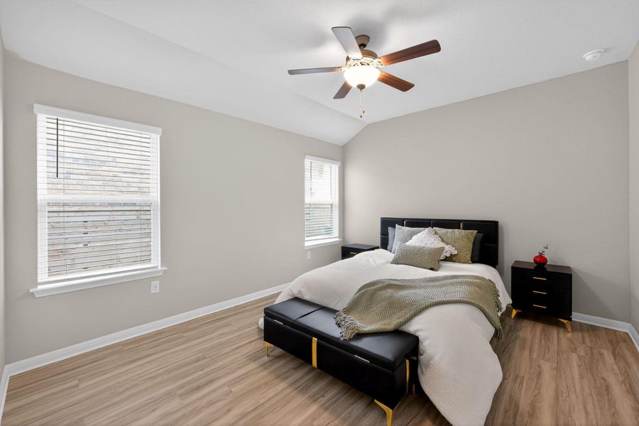 Bedroom with light wood-type flooring, lofted ceiling, and ceiling fan