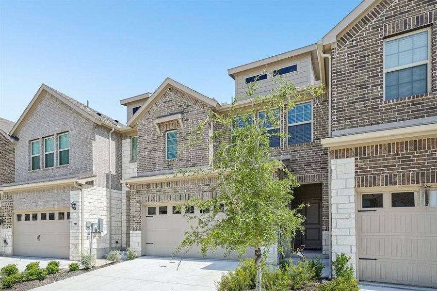 View of front of home with brick siding, concrete driveway, and a garage View of front of home with brick siding, concrete driveway, and a garage