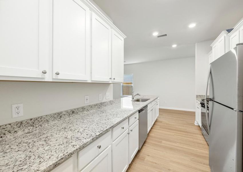 Enjoy stunning granite countertops and designer wood cabinetry in this kitchen.