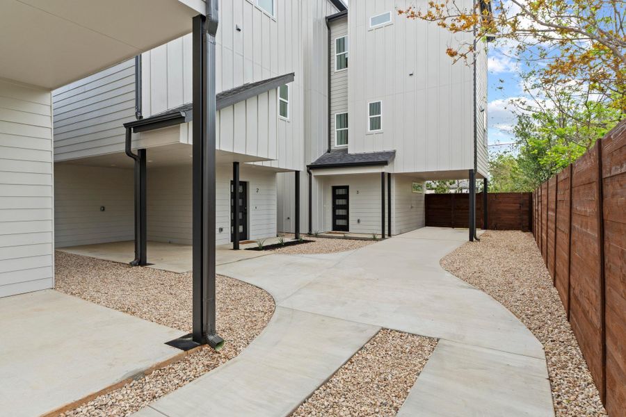 Crisp vertical siding paired with concrete walkways creates a striking modern architectural aesthetic.
