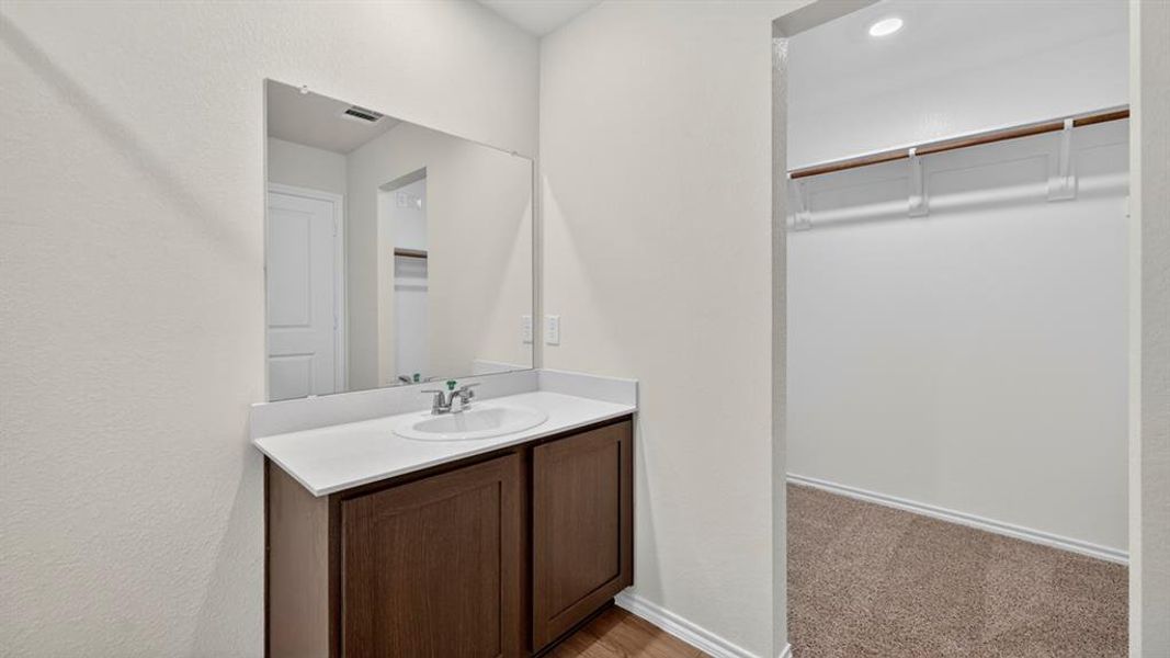 Vanity with a white countertop and dark wood-finish cabinetry
