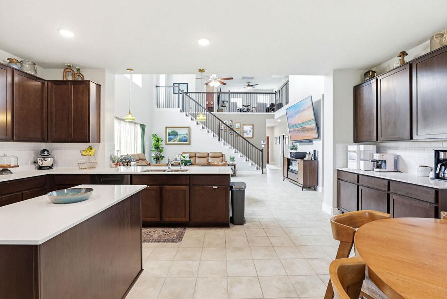 Kitchen with dark wood-finish cabinetry, white countertops, and a white subway tile backsplash
