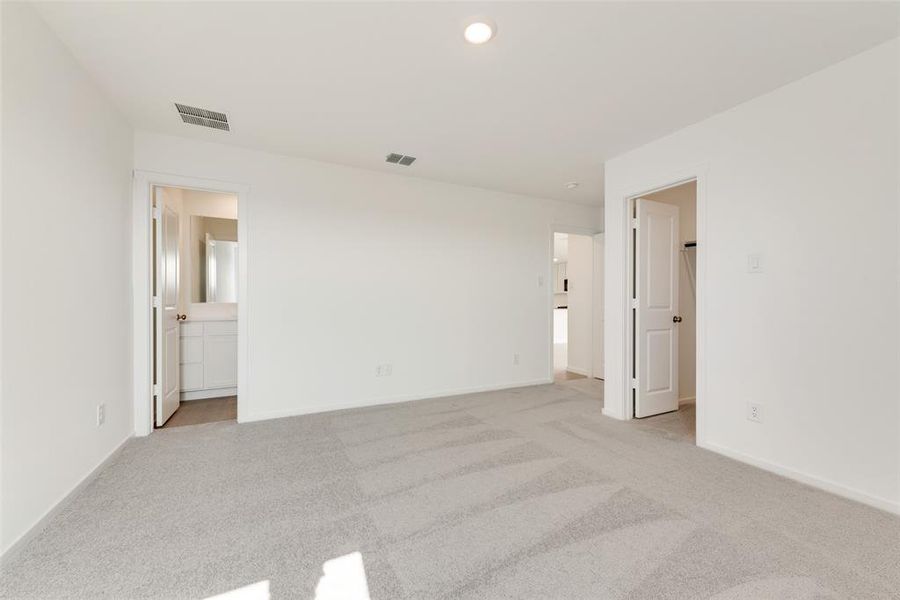 Unfurnished bedroom with connected bathroom, light colored carpet, and recessed lighting Unfurnished bedroom with connected bathroom, light colored carpet, and recessed lighting