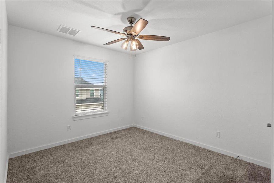 A quiet retreat with a window overlooking the neighborhood and a ceiling fan for comfort.