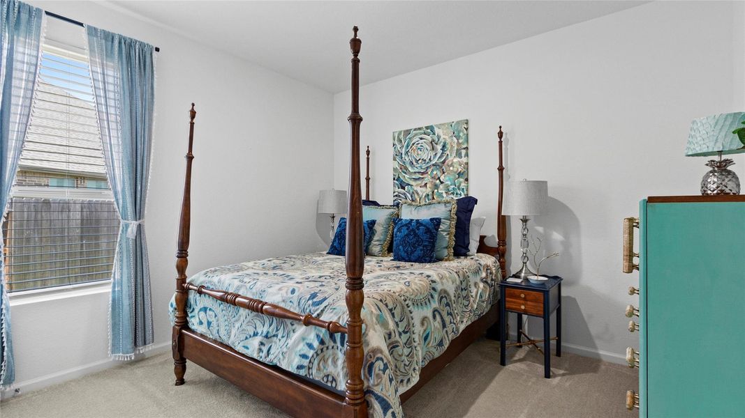 This charming secondary bedroom offers abundant natural light from a large window, complemented by stylish blue window treatments and an inviting atmosphere. This charming secondary bedroom offers abundant natural light from a large window, complemented by stylish blue window treatments and an inviting atmosphere.