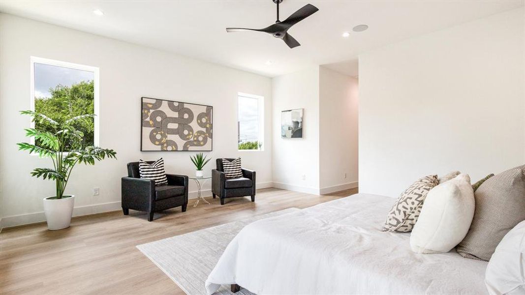 Bedroom with ceiling fan, light hardwood / wood-style flooring, and multiple windows