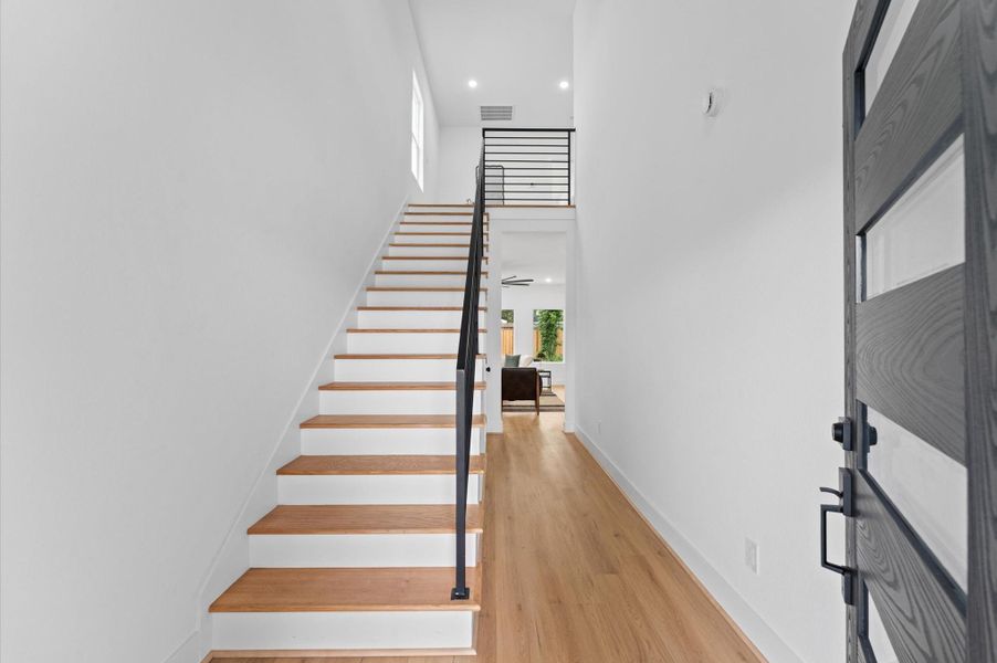 Step inside and note the gorgeous engineered wood flooring that runs continuously throughout most of the home.