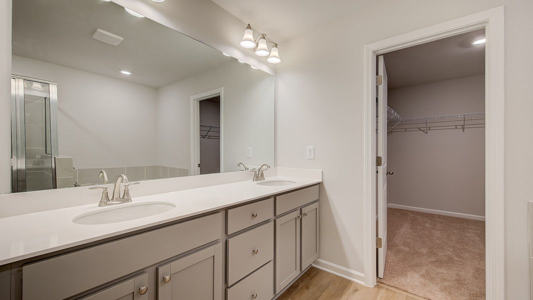 Ridgewood bright and modern primary bath with dual vanities with quartz countertops at Bowers Farm.