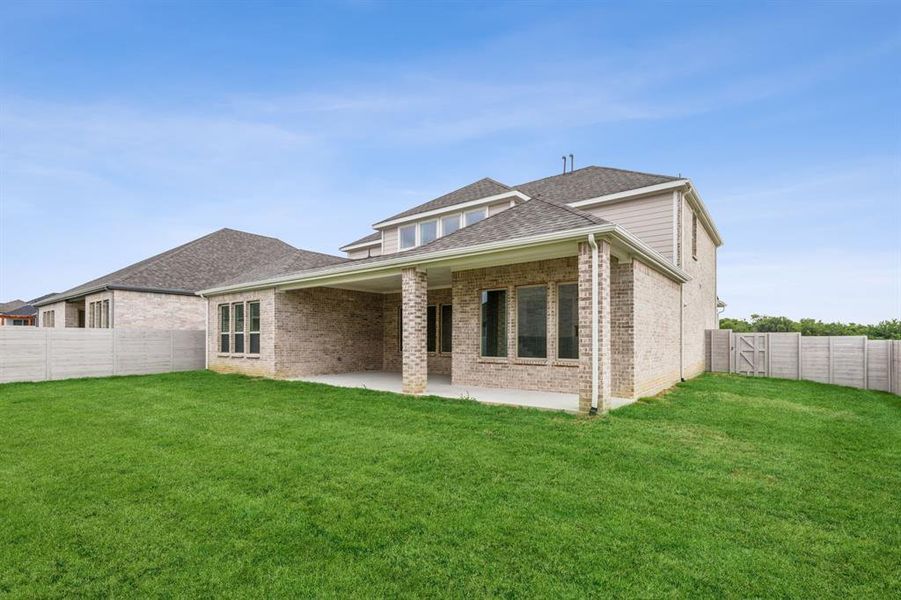 Rear view of property with a patio and a yard