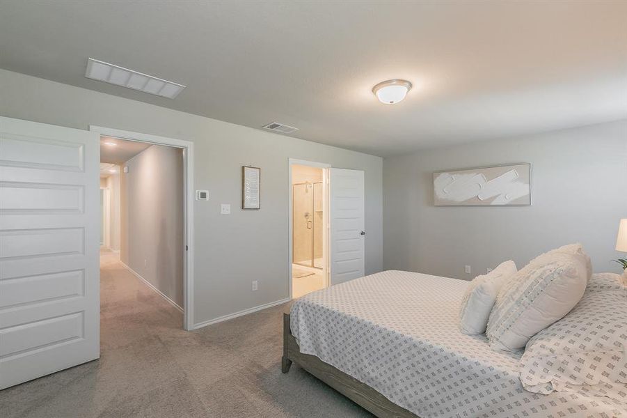 Carpeted bedroom with baseboards and ensuite bath