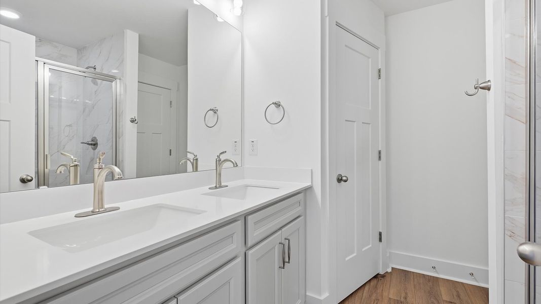 Accomplished design shines in this primary bath with dual vanity and a sleek walk-in shower in Arden, NC