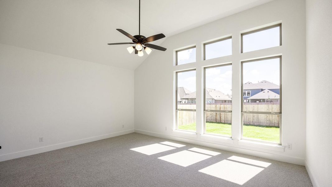 Empty room featuring light colored carpet, a residential view, high vaulted ceiling, and ceiling fan