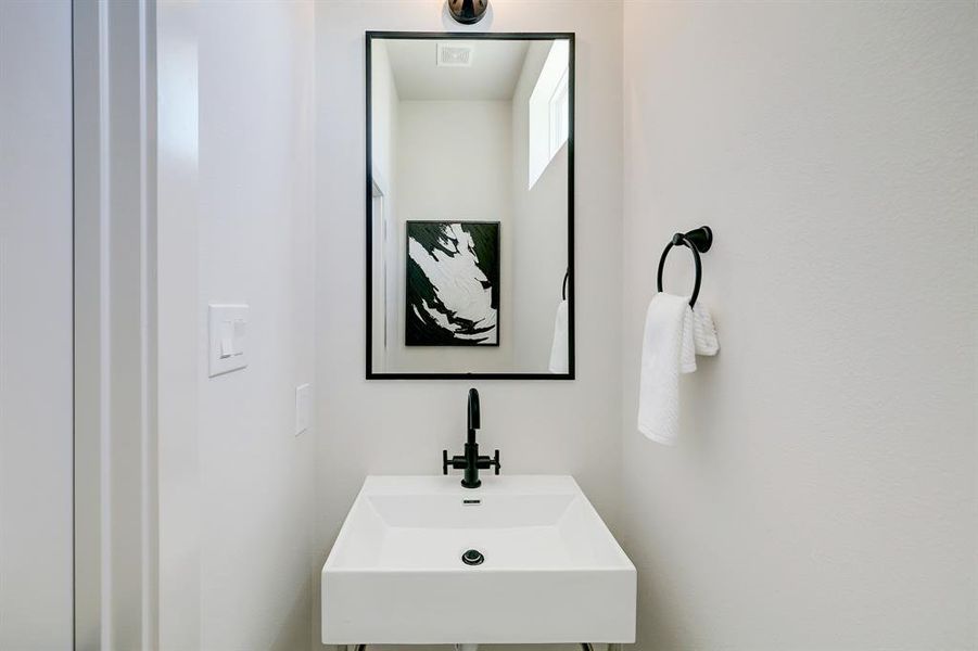 The powder bathroom includes adecorative pedestal sink.