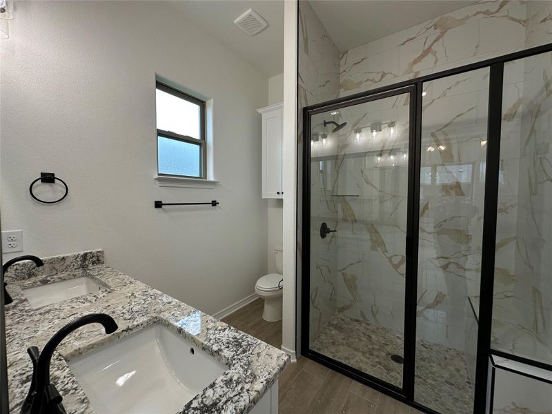 Dual vanity featuring granite countertops and undermount sinks with matte black fixtures