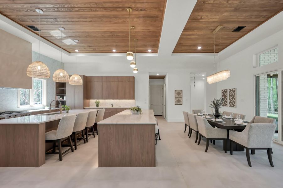 Bathed in natural light, the kitchen seamlessly connects to the surrounding living spaces and outdoor views, enhancing the home’s open, airy feel.