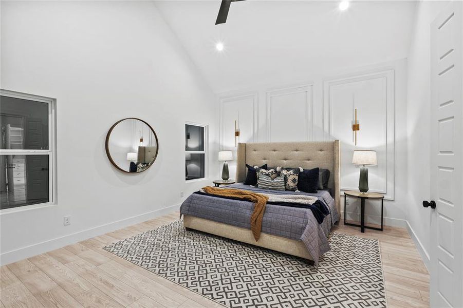 Bedroom with ceiling fan, high vaulted ceiling, and light wood-type flooring