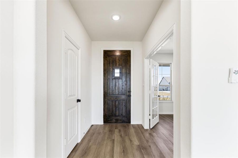 Entryway with wood finished floors and recessed lighting
