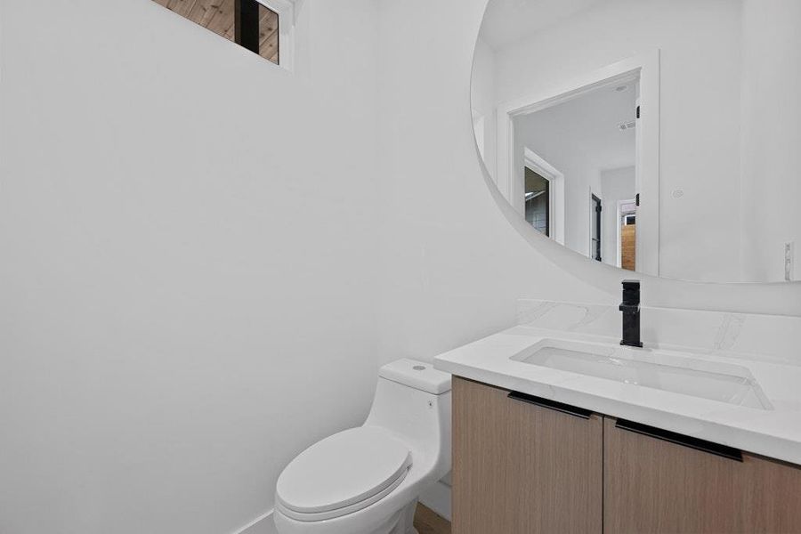 Half bathroom with vanity and toilet