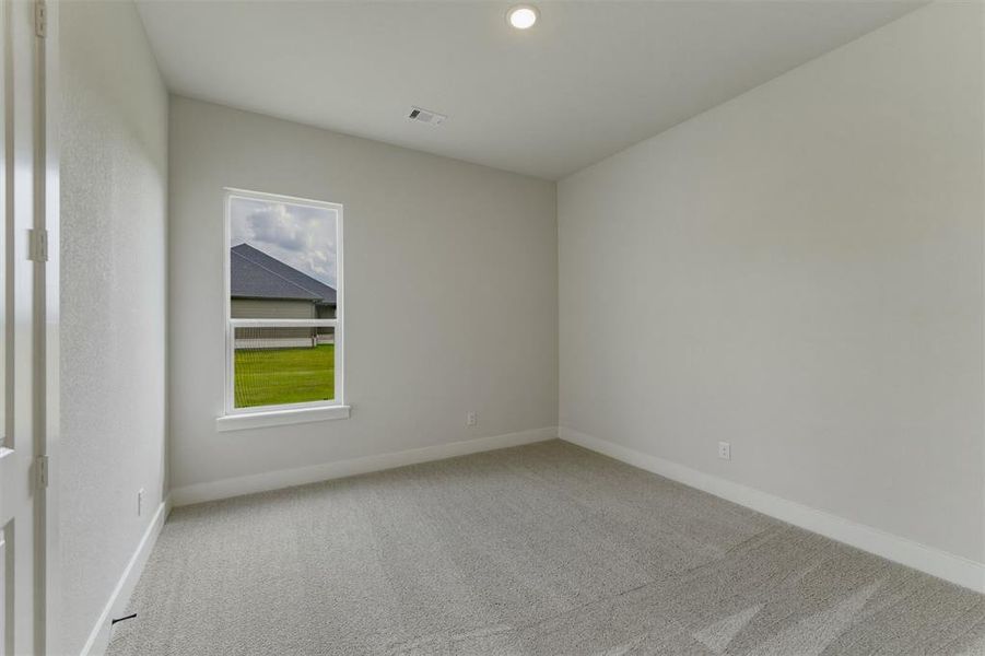Carpeted room with a single window, white trim, and a recessed ceiling light Carpeted room with a single window, white trim, and a recessed ceiling light