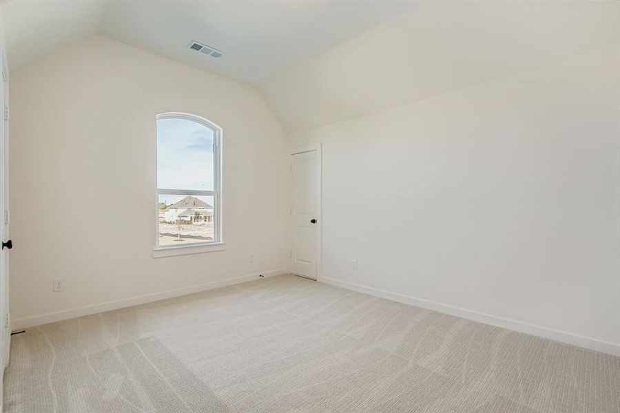 Bonus room with light carpet and vaulted ceiling