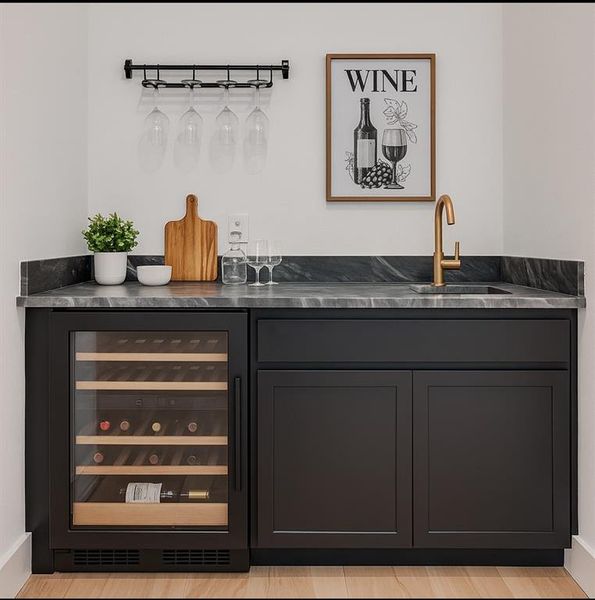 Indoor wet bar featuring beverage cooler and baseboards