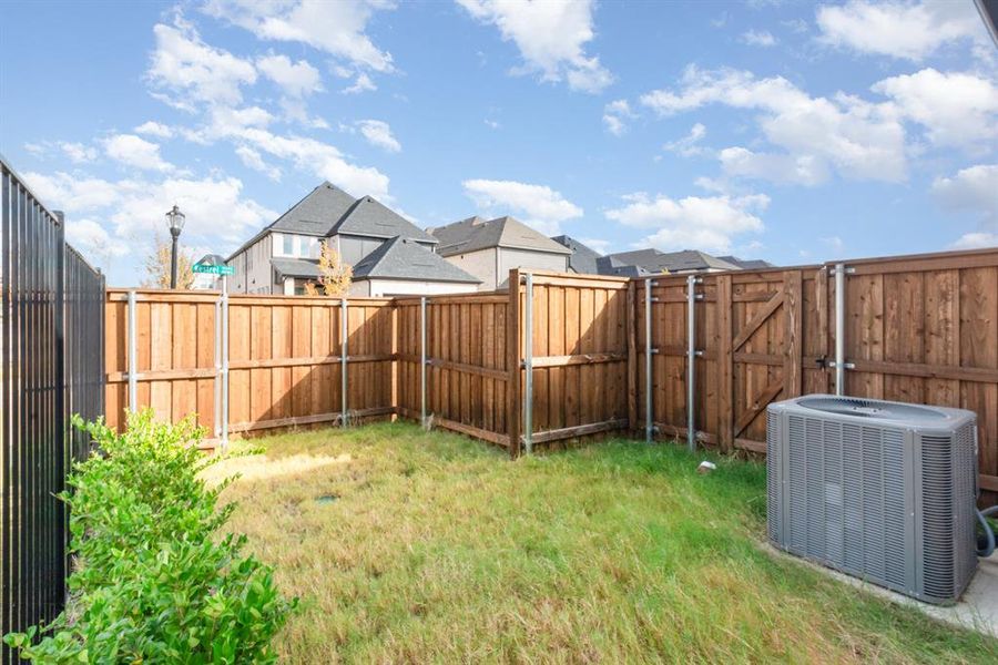 Fenced backyard with a gate and a residential view Fenced backyard with a gate and a residential view