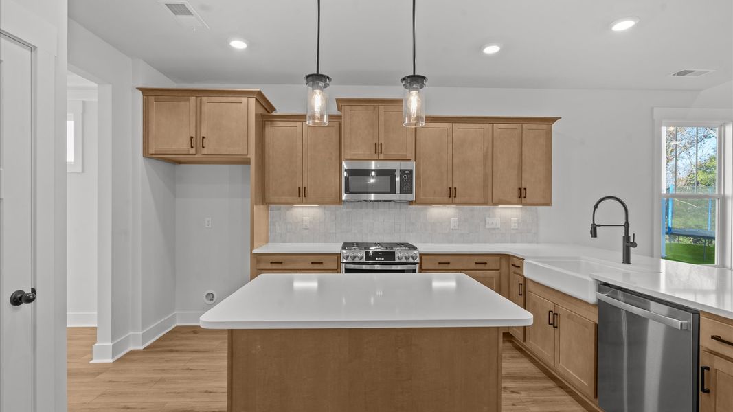 Accomplished kitchen design featuring pendant lighting above a statement island for both prep and gathering Accomplished kitchen design featuring pendant lighting above a statement island for both prep and gathering