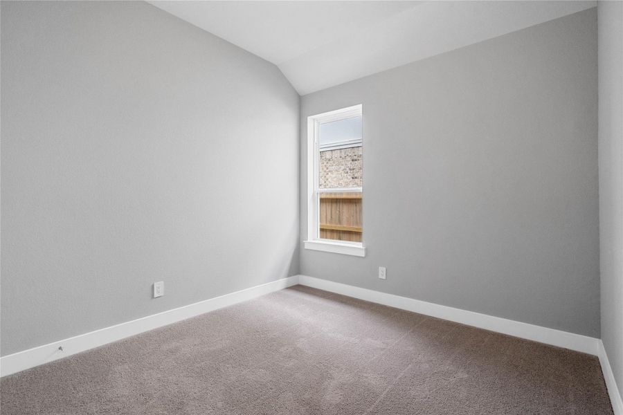 This cozy secondary bedroom offers plush soft carpeting, neutral walls ready for personalization, a sun-filled window, sloped ceilings, and a spacious closet for all your storage needs.