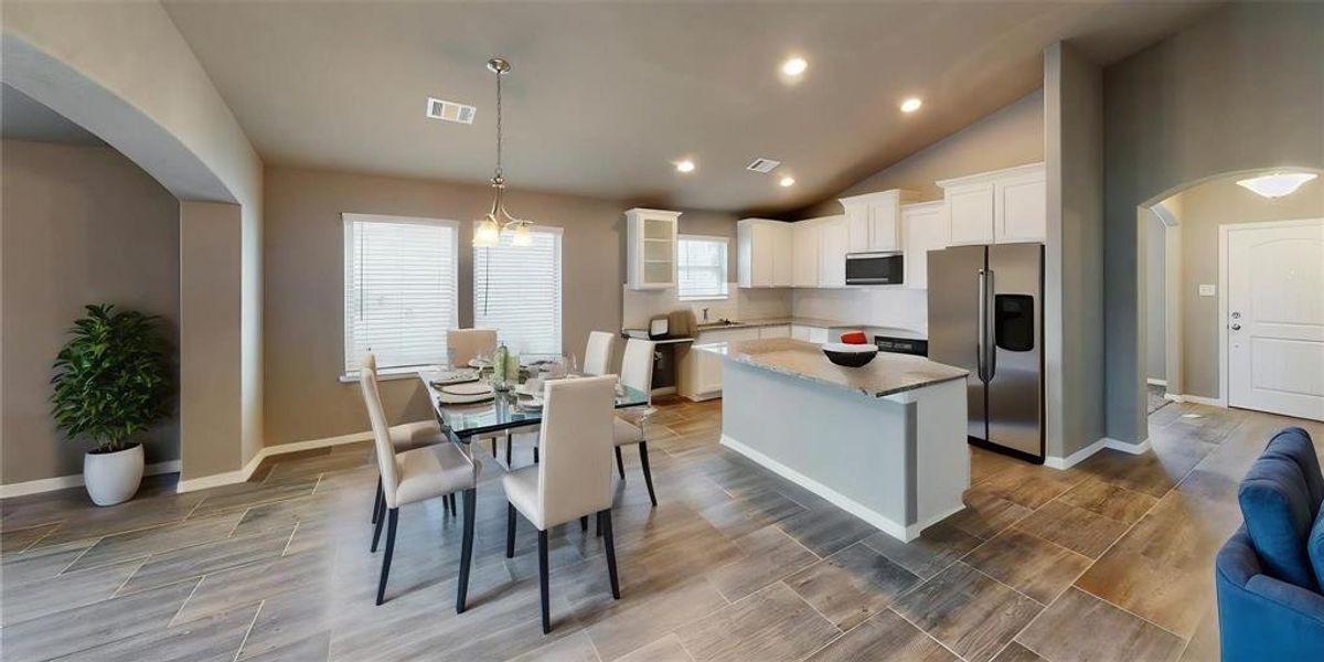 This image captures the connection between the kitchen and dining area, showcasing the functional and stylish design. The granite countertops, modern cabinetry, and spacious layout make it a perfect setting for family meals and entertaining guests. This is a picture of an Elise Floor Plan with another Saratoga Homes.