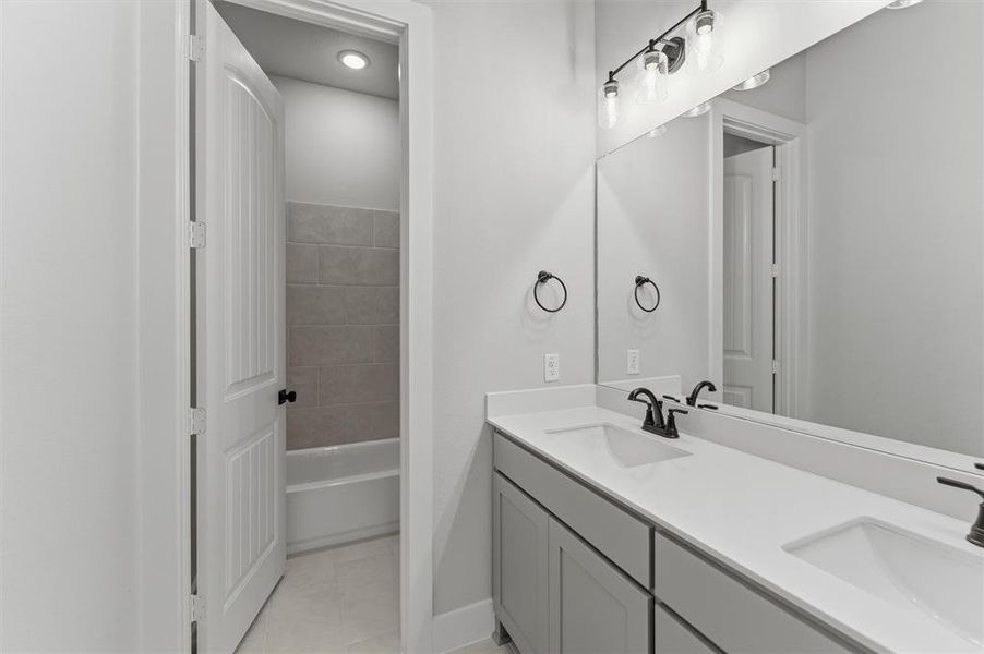 Full bathroom featuring double vanity and light tile patterned flooring