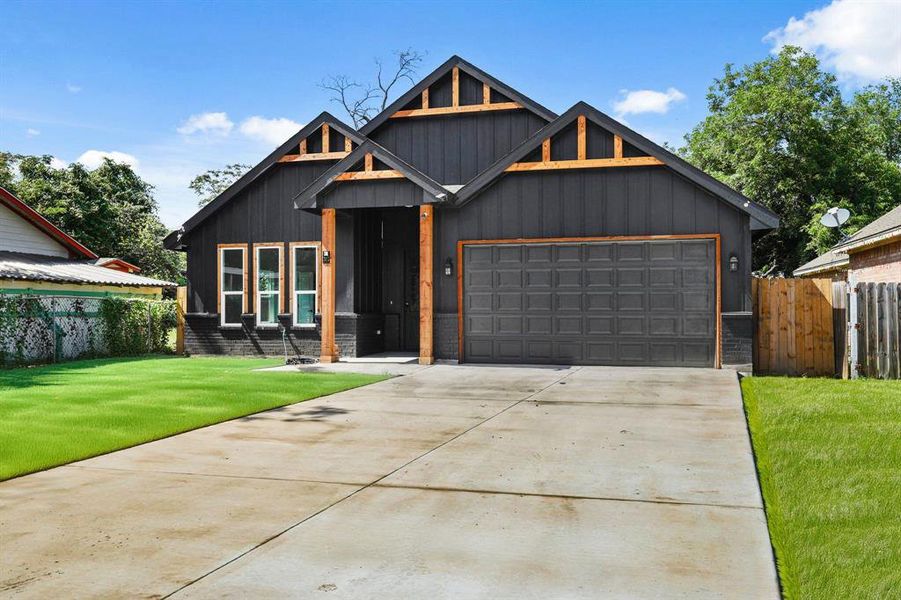 View of front of home with driveway, an attached garage, and board and batten siding
