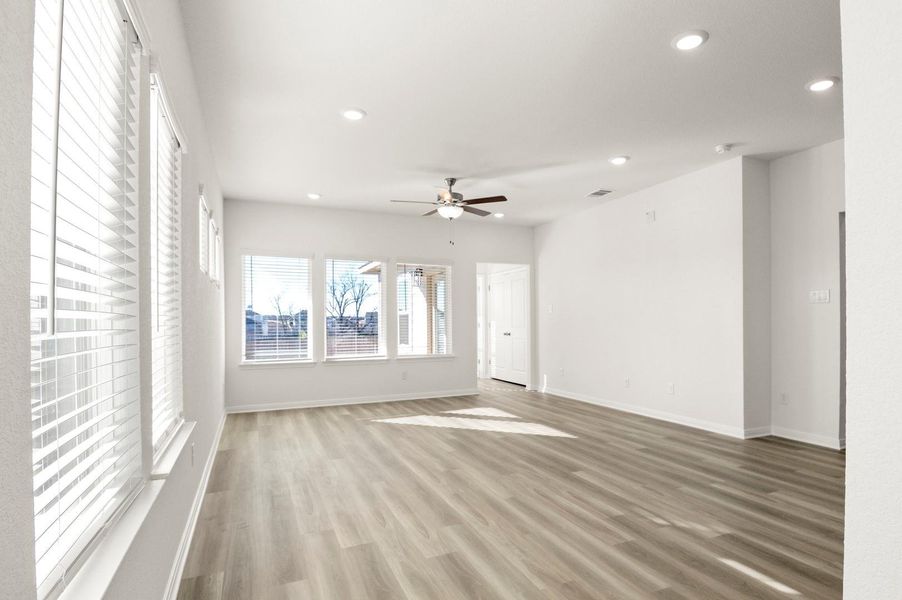 Unfurnished living room featuring light wood-type flooring, a ceiling fan, and recessed lighting