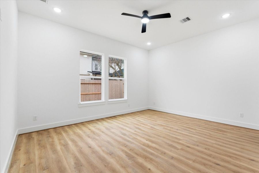 The spacious primary bedroom features continued luxury vinyl flooring, a ceiling fan, and a spa-like en suite with an ample walk-in closet.