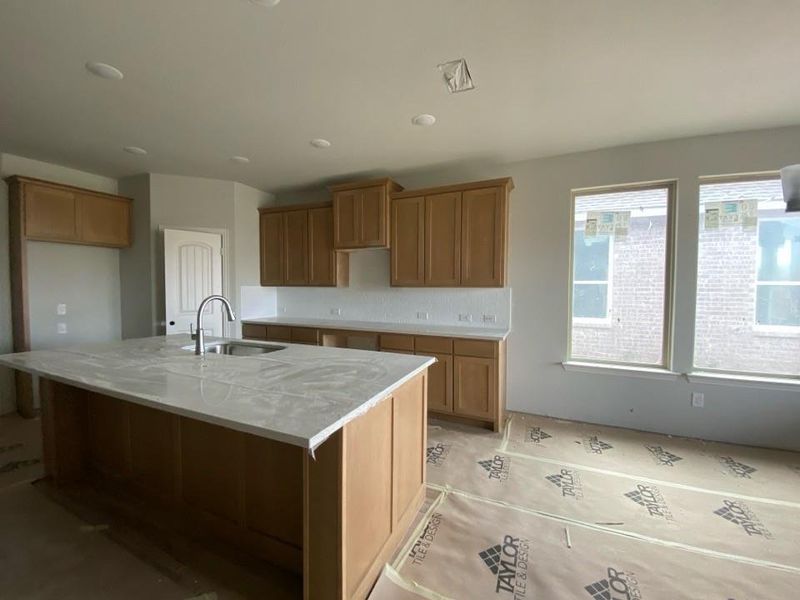 Kitchen featuring a central island with an undermount sink and a gooseneck faucet