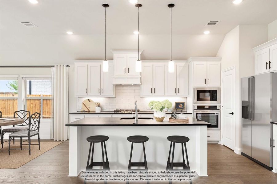 Kitchen with white cabinets, dark island with three stools, pendant lights, and stainless steel appliances Kitchen with white cabinets, dark island with three stools, pendant lights, and stainless steel appliances