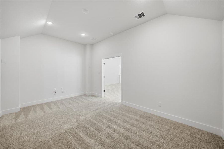 Spare room with vaulted ceiling, carpet, and recessed lighting Spare room with vaulted ceiling, carpet, and recessed lighting