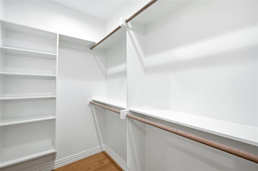 Walk in closet featuring light wood-style flooring Walk in closet featuring light wood-style flooring