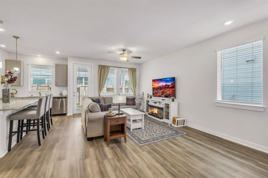 Sun-filled living room featuring oversized windows, high ceilings, and a warm, inviting atmosphere perfect for gathering with family and friends.