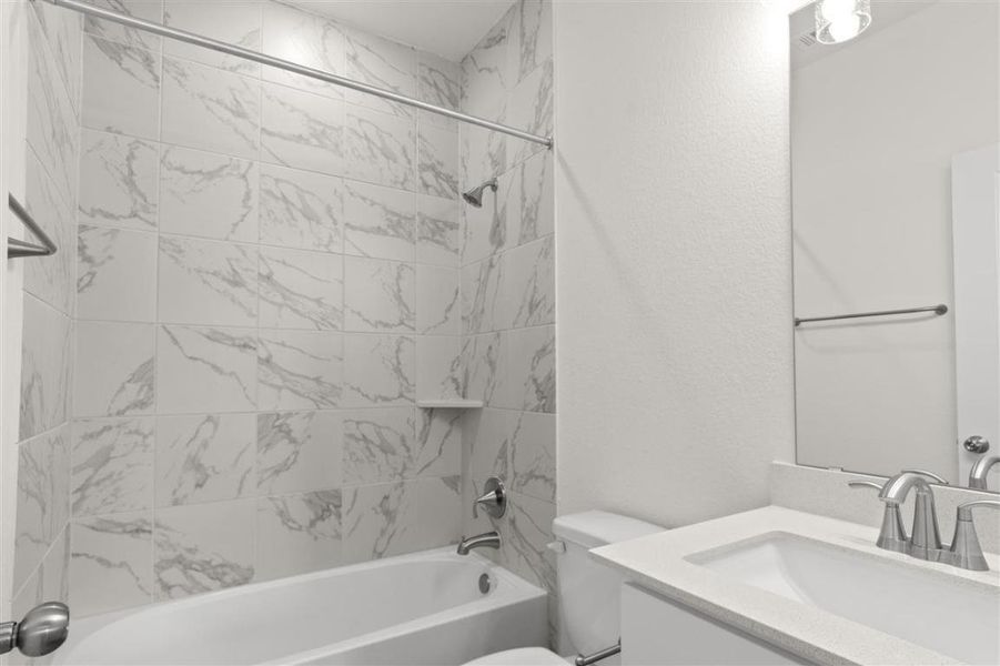 Bathroom featuring  shower combination, a textured wall, toilet, and vanity