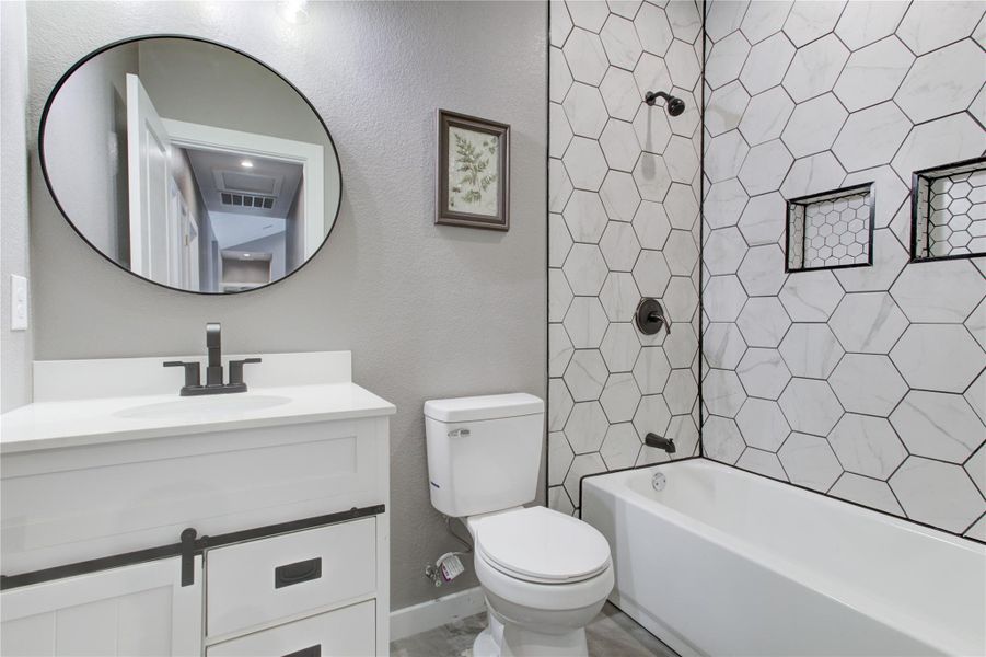 Bathroom featuring toilet, vanity, and tub / shower combination