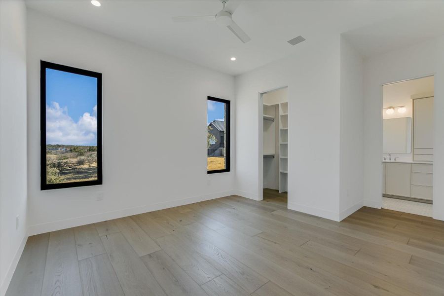 Unfurnished bedroom with recessed lighting, a walk in closet, light wood-style floors, a ceiling fan, and connected bathroom
