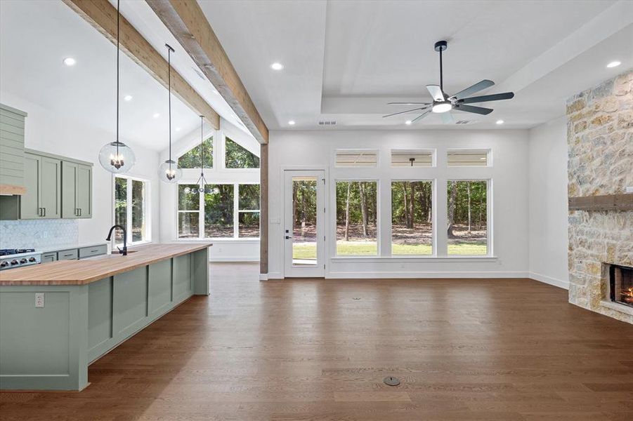 Kitchen featuring butcher block counters, green cabinetry, pendant lighting, dark wood-style flooring, and a chandelier Kitchen featuring butcher block counters, green cabinetry, pendant lighting, dark wood-style flooring, and a chandelier