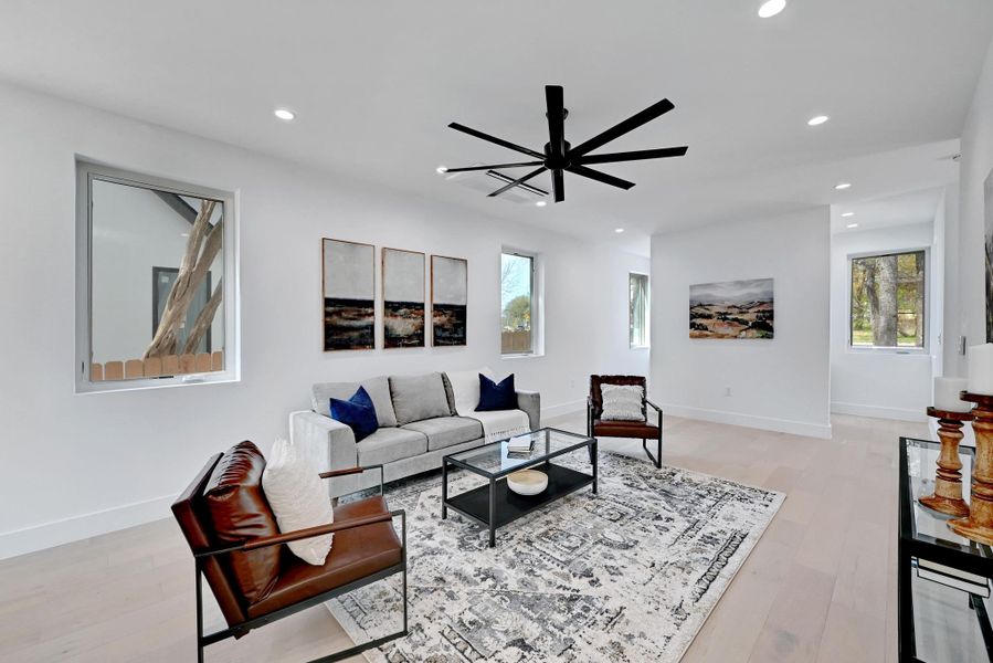 Living room featuring a ceiling fan, recessed lighting, light wood-style floors