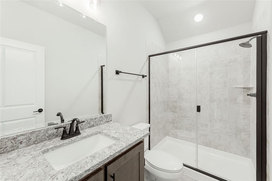 Bathroom with granite vanity, glass-enclosed tub and shower, and dark bronze fixtures Bathroom with granite vanity, glass-enclosed tub and shower, and dark bronze fixtures