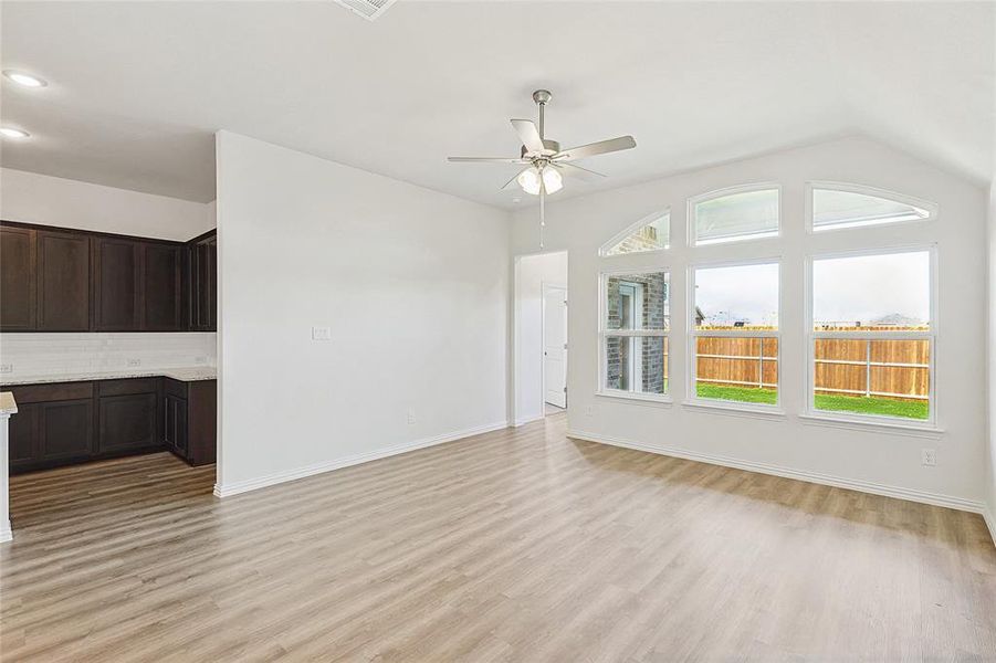 Unfurnished living room featuring ceiling fan, lofted ceiling, and light hardwood / wood-style flooring