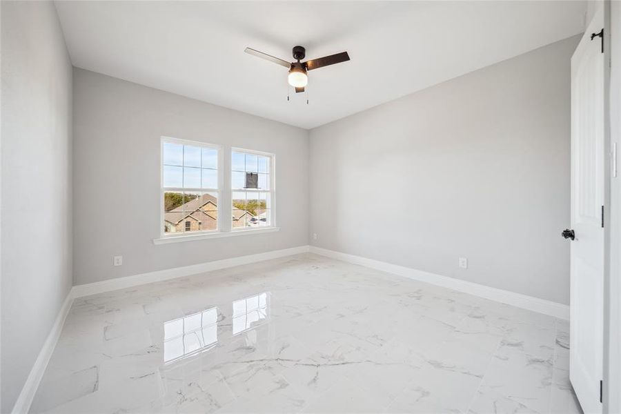 Room featuring large format white tile flooring, light gray wall paint, and white baseboards