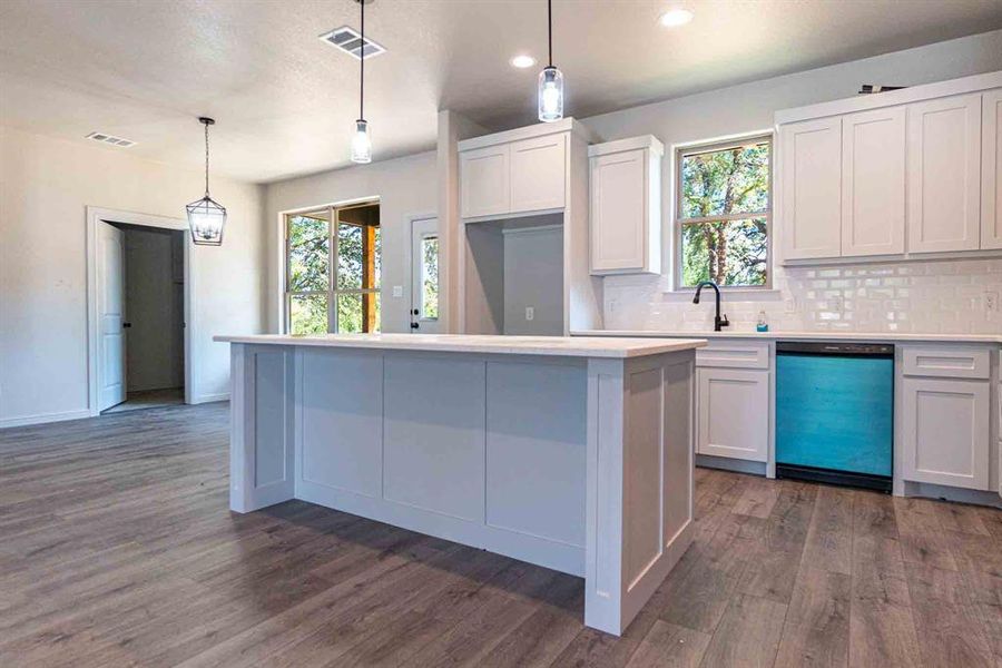 Kitchen featuring tasteful backsplash, decorative light fixtures, dishwasher, dark wood-style floors, and recessed lighting