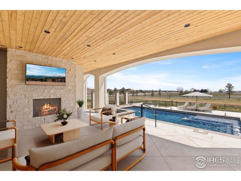Beautiful outdoor living space with gas fireplace, TV, and built in gas grill